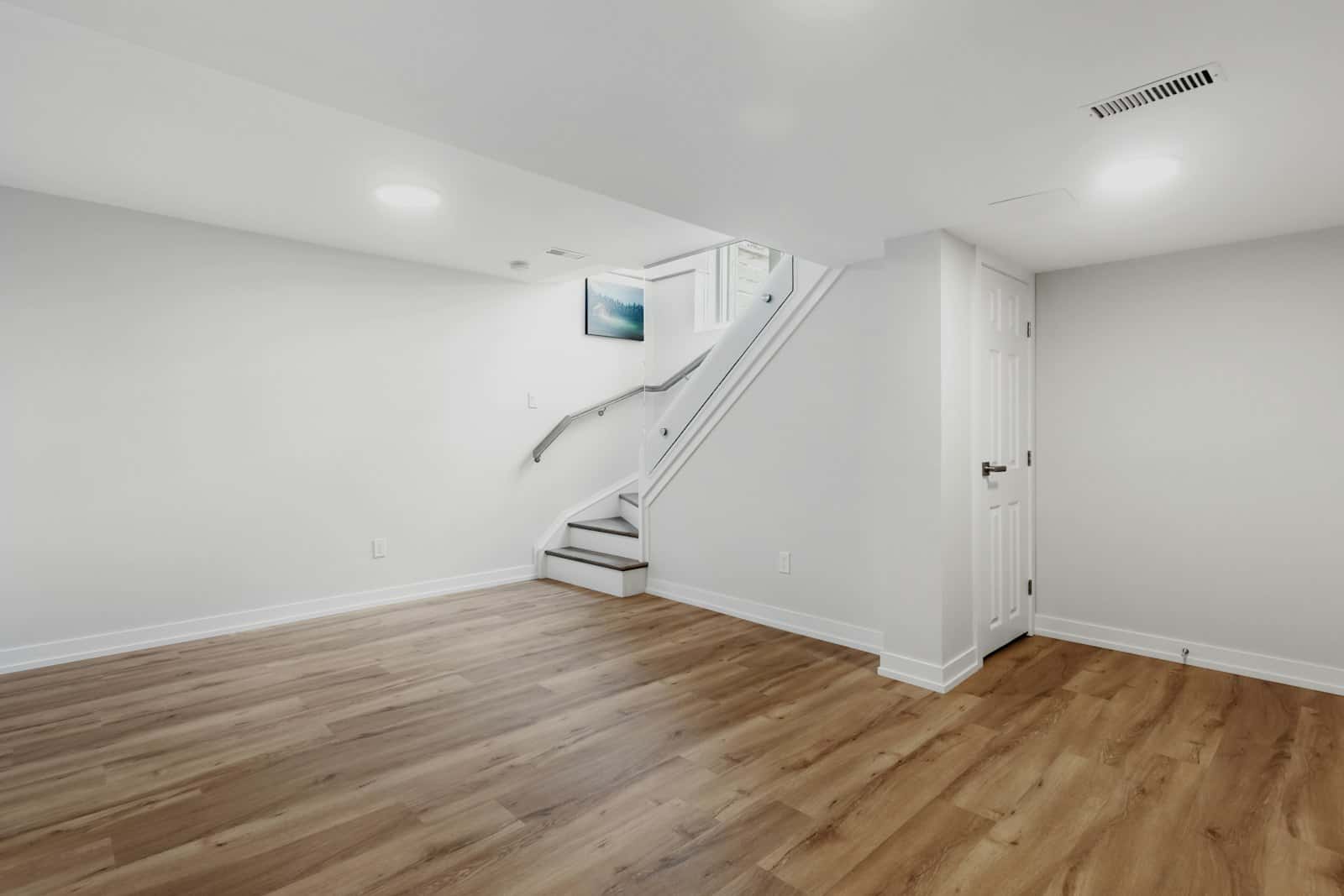 Clean, renovated basement with new flooring and staircase