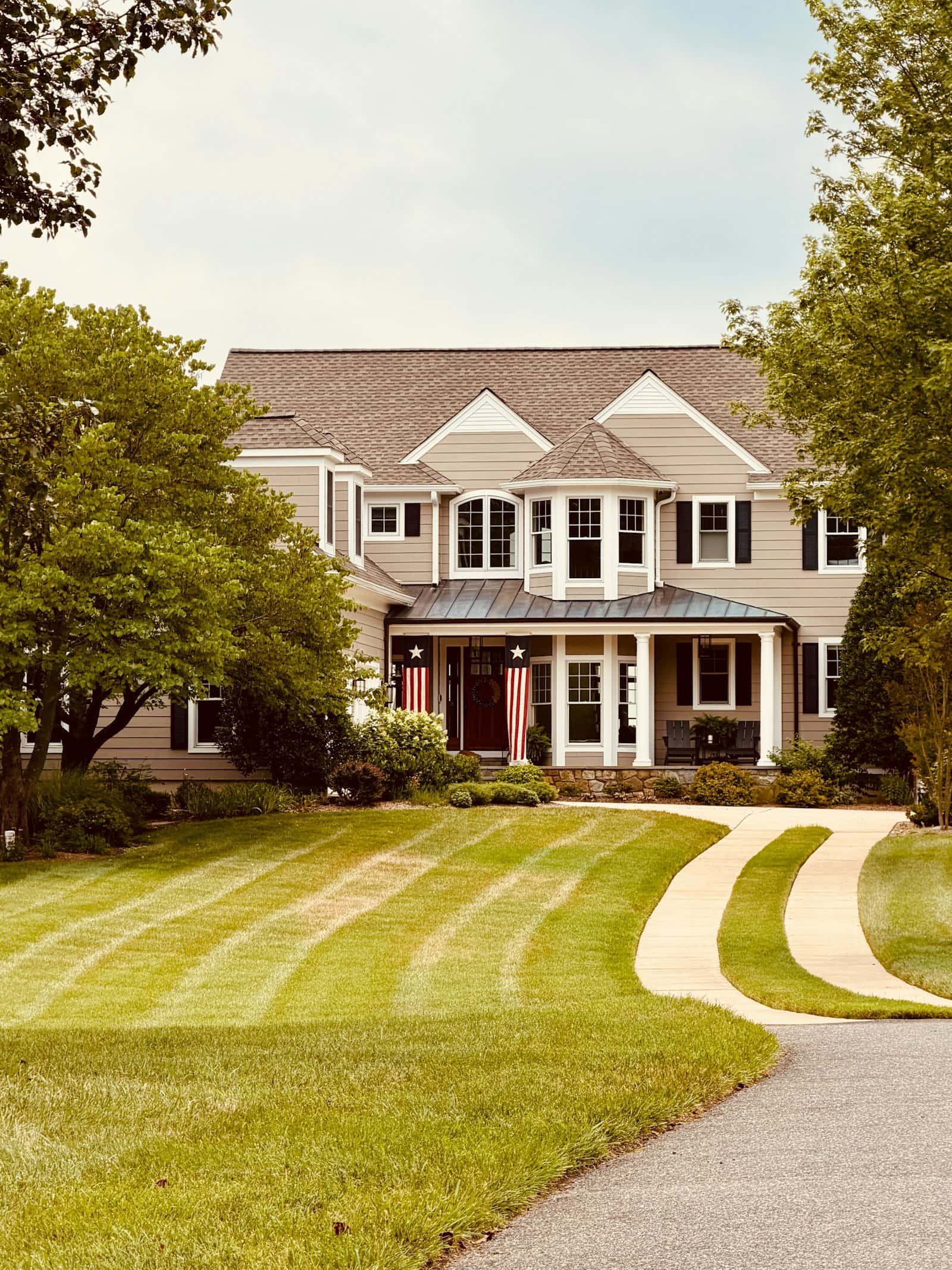 Long curved driveway and walkway leading to a large home
